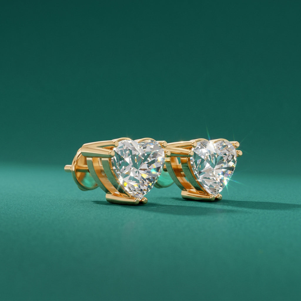 Heart-shaped diamond earrings with gold setting on a white background