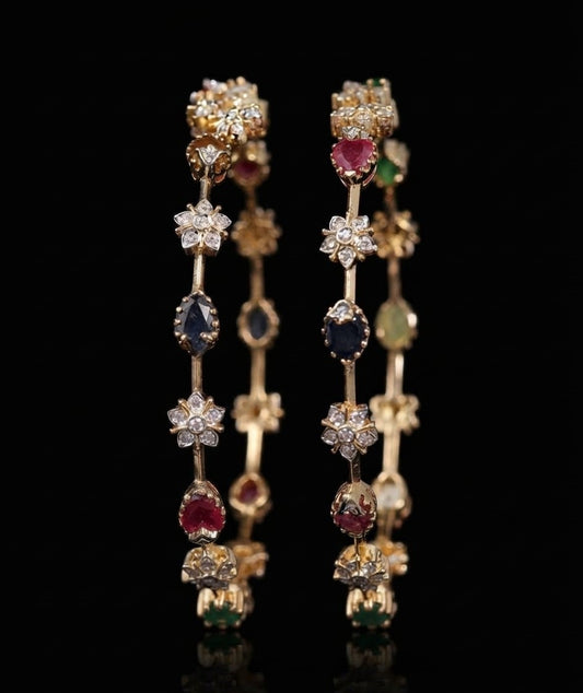 Pair of traditional gold bangles set with lab grown diamond cluster flowers and ruby, sapphire, and emerald gemstones