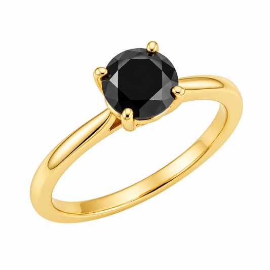 A yellow gold solitaire ring with a round black gemstone in a four-prong setting, shown on a clean white background with a soft reflection below.