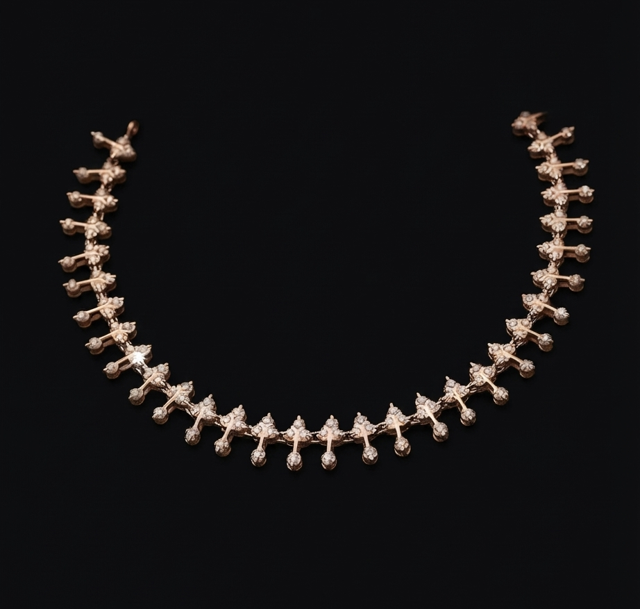 A delicate yellow gold necklace featuring a repeating pattern of small, pointed starburst or leaf-like motifs, set with clear stones against a solid black background.