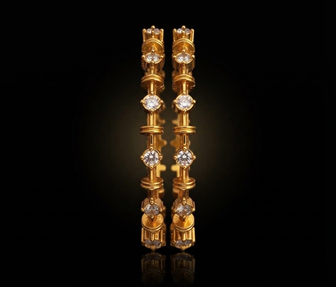 Pair of traditional South Indian gold bangles featuring bezel-set round white stones with textured link pattern.
