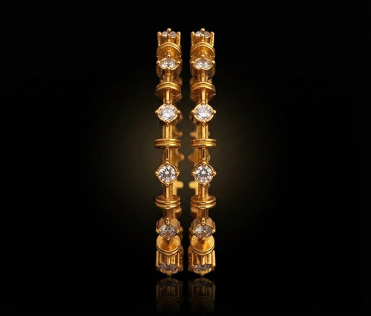 Pair of traditional South Indian gold bangles featuring bezel-set round white stones with textured link pattern.