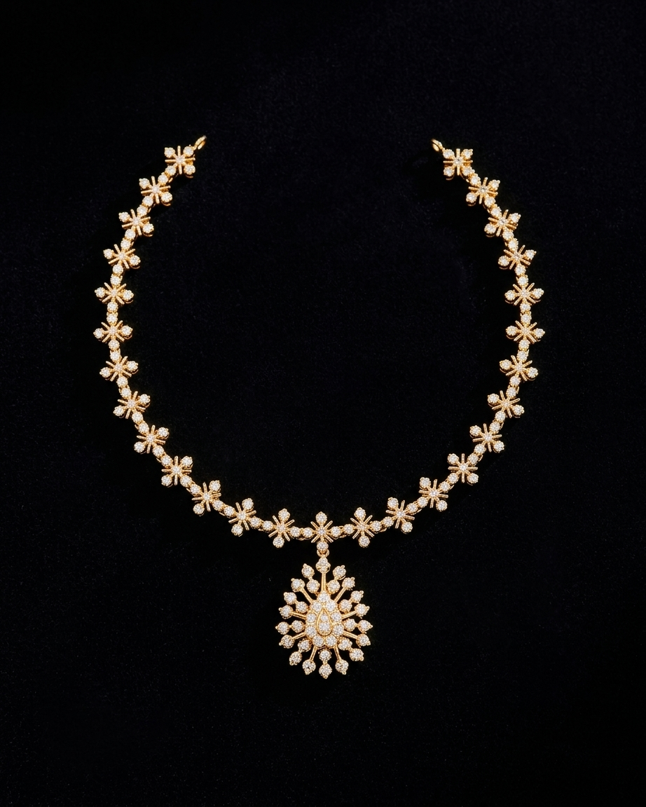 A South Indian gold haram necklace displayed against a black background. The necklace strand consists of repeating starburst floral motifs set with clear stones. At the bottom center, a matching teardrop-shaped pendant featuring radiant stone rays hangs elegantly from the chain