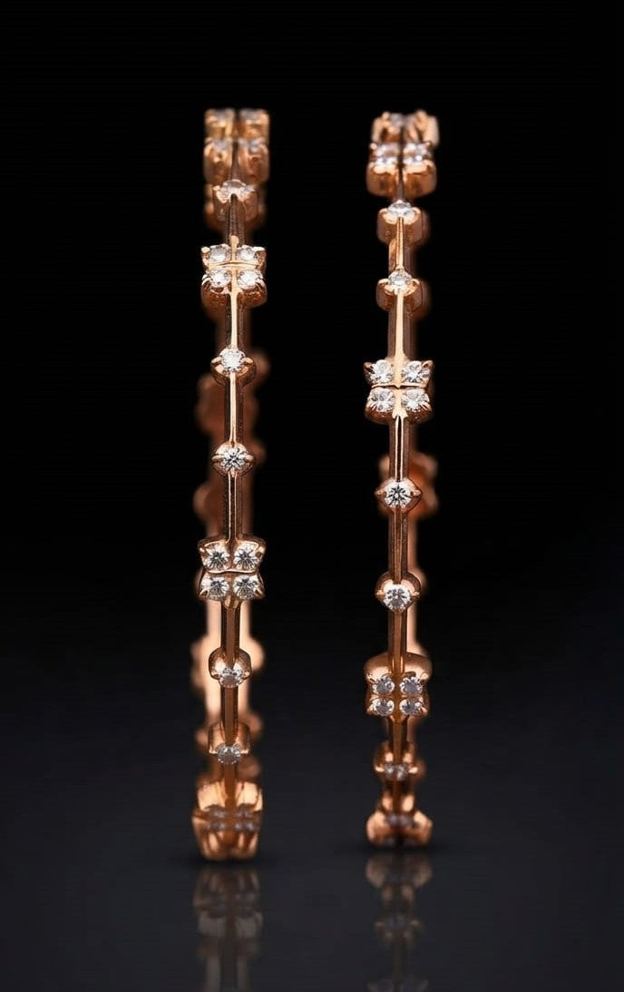 Pair of modern South Indian lab grown diamond bangles in gold featuring alternating four-stone floral motifs and bezel-set round accent diamonds connected by a slender bar frame.