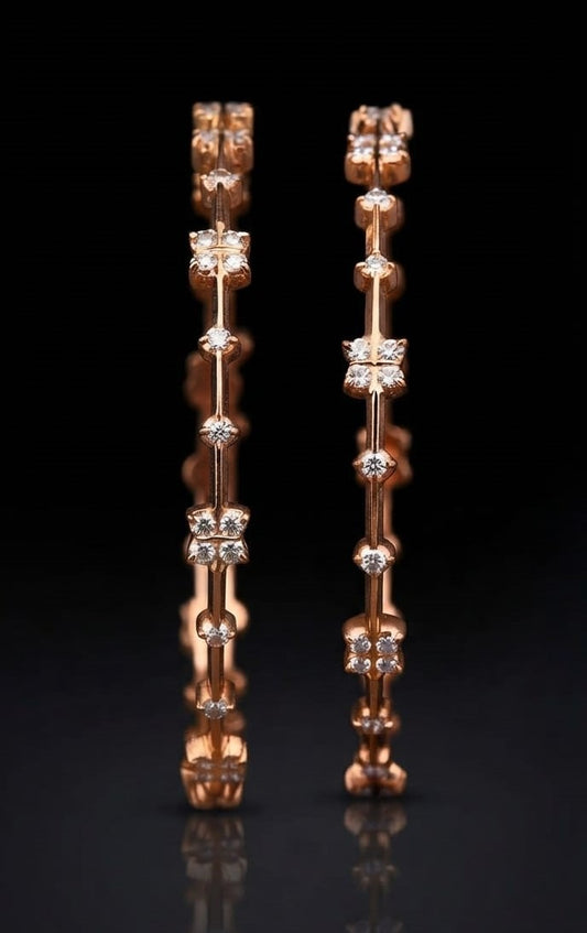 Pair of modern South Indian lab grown diamond bangles in gold featuring alternating four-stone floral motifs and bezel-set round accent diamonds connected by a slender bar frame.