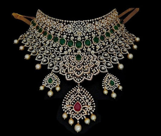 Heavy Indian bridal diamond choker set studded with oval green emeralds, pear-shaped ruby centerpiece, hanging pearl beads, and matching chandelier earrings.