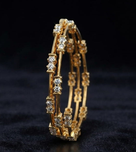Pair of classic South Indian yellow gold bangles featuring spaced two-stone round lab grown diamond stations along a slender structural metal bar frame.